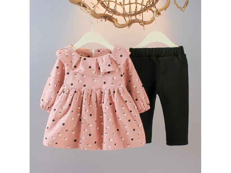 Pink baby girl outfit set with long sleeve dress and black pants on hangers.