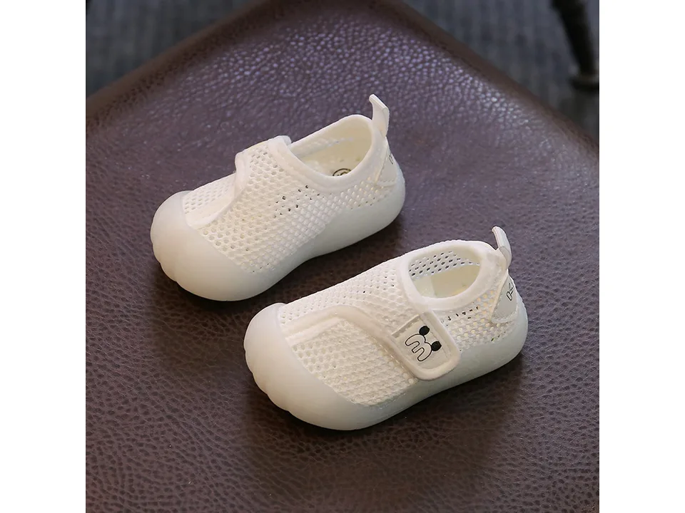 Pair of white breathable mesh baby sneakers with velcro closure.