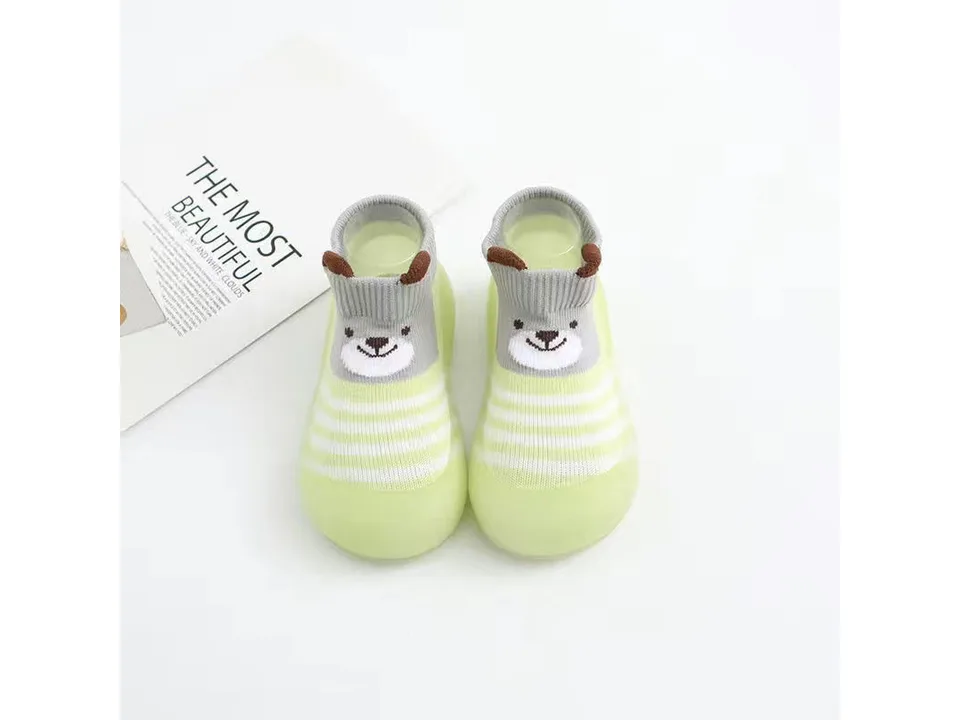 A pair of light green toddler sock shoes with a bear face design.