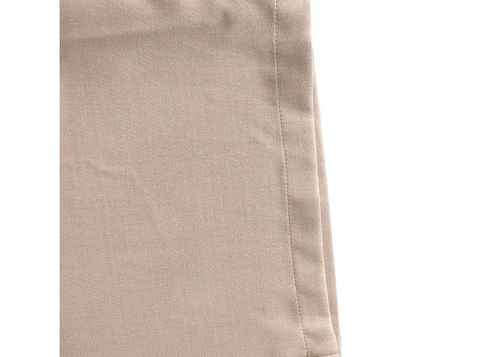 Close-up view of the beige fabric texture and stitching on the jumpsuit.