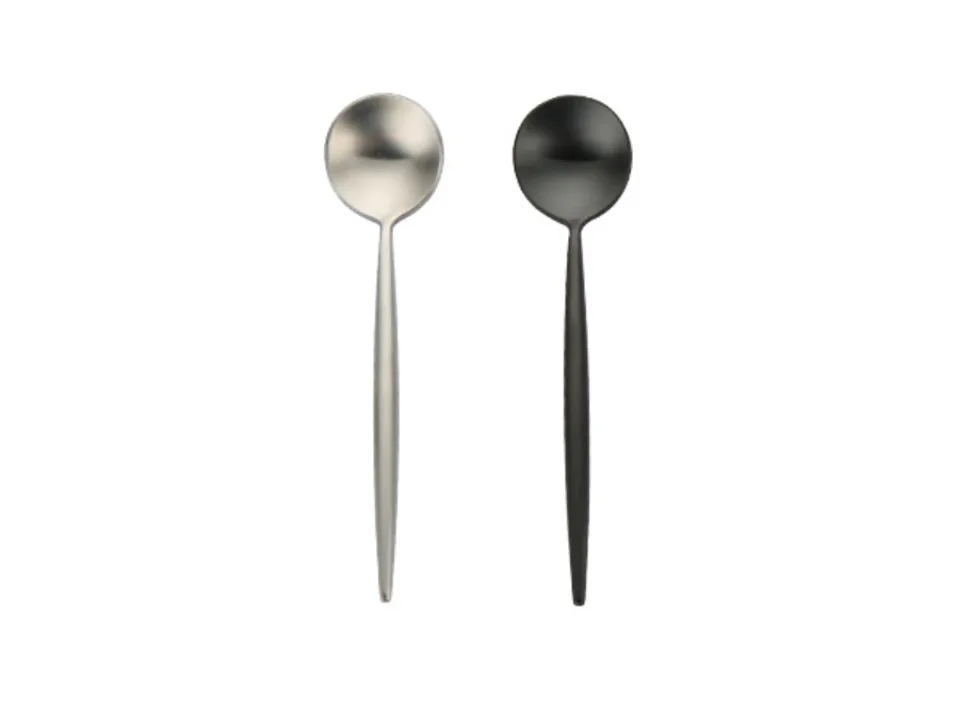 Two stainless steel spoons, one silver and one black, side by side.