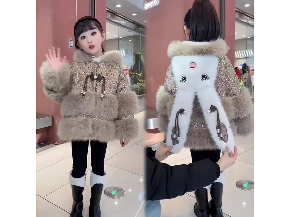 A girl wearing a brown faux fur winter coat with a rabbit design on the back.
