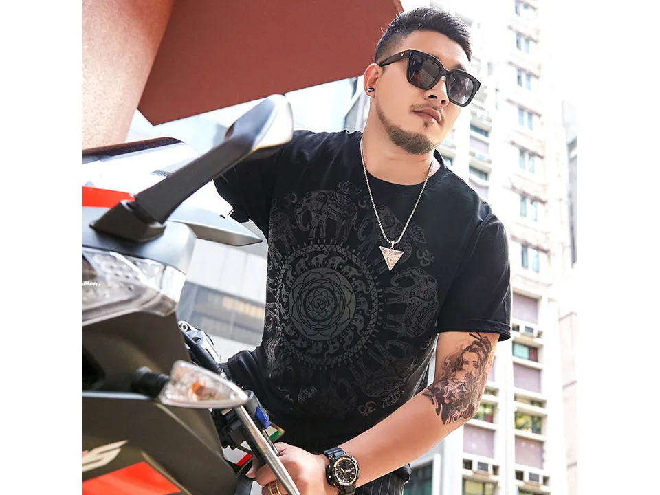 A man wearing a black t-shirt with an elephant mandala print.