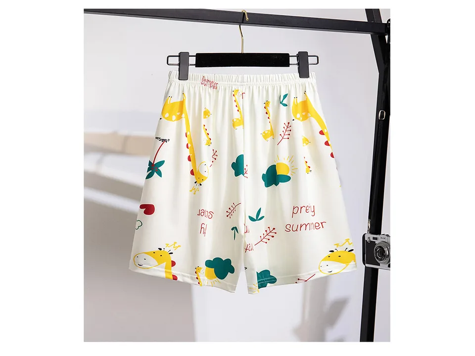 Women's pajama shorts with a giraffe and summer print hanging on a rack.