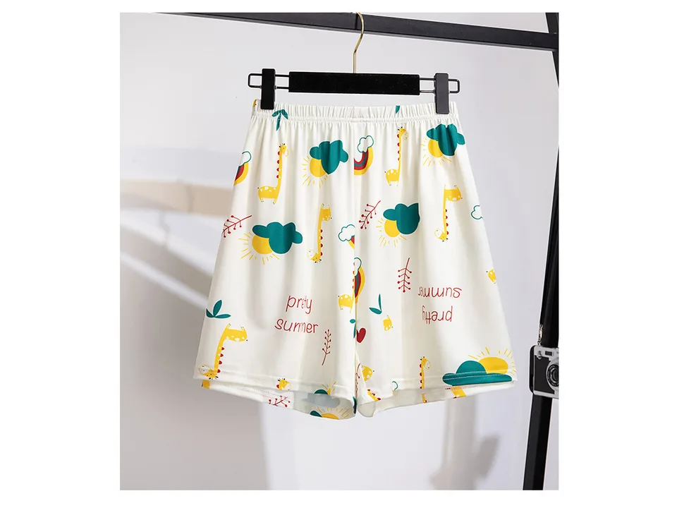 Women's pajama shorts with a giraffe and summer print hanging on a rack.