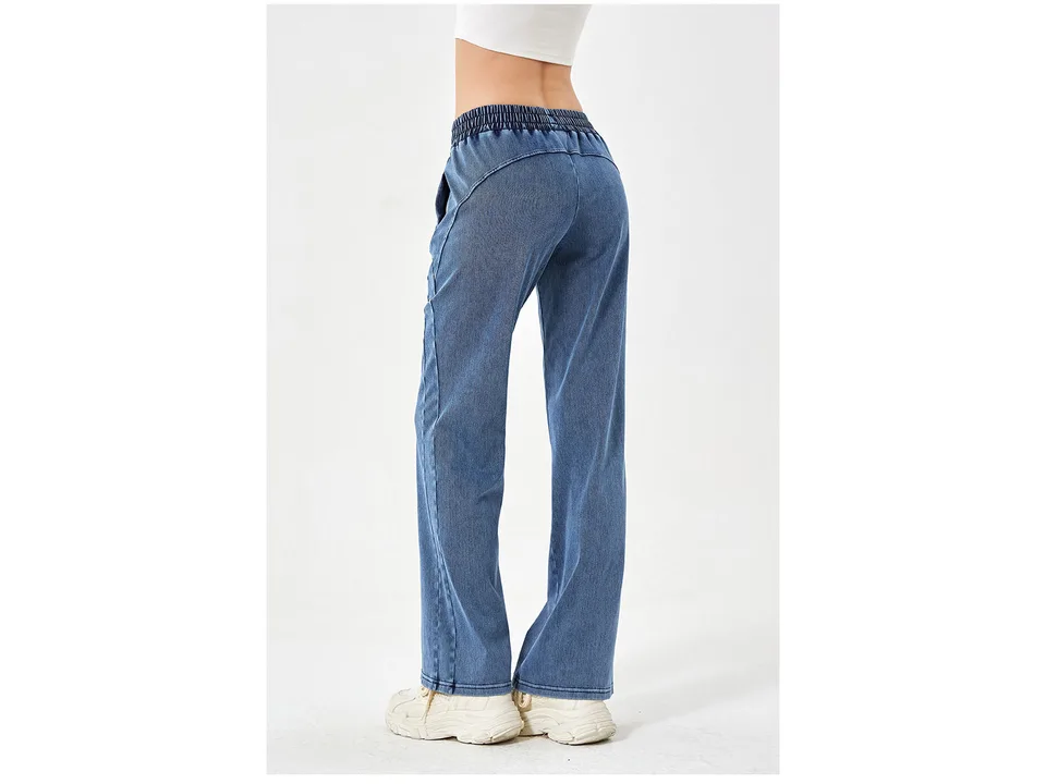 Back view of a woman wearing blue loose fit denim jeans.