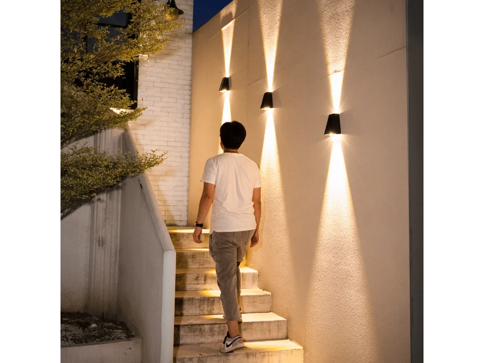 Multiple solar wall lamps installed along an outdoor staircase at night.