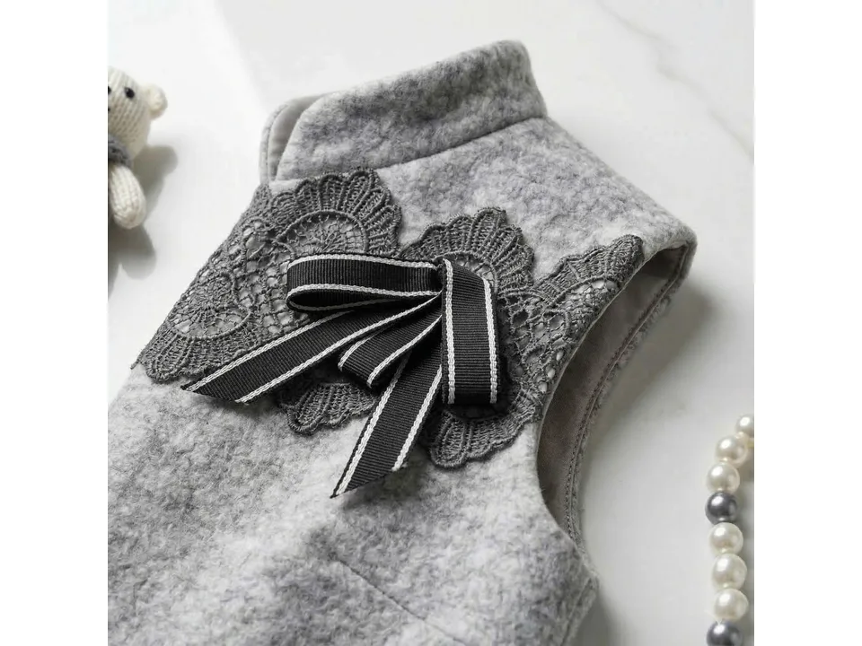 Close-up of the grey wool blend dress showing lace trim and a black bow detail.
