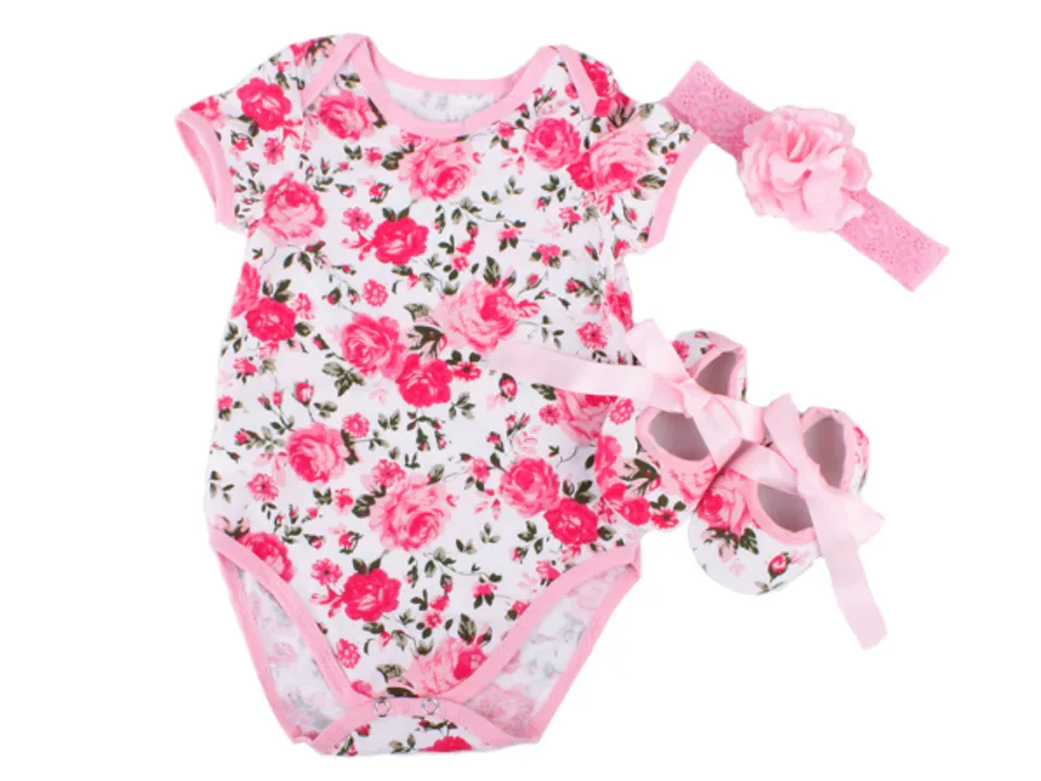 Baby romper set with pink floral print, matching headband, and shoes.