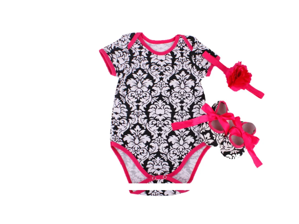 Baby romper set with black and white damask print, matching headband, and shoes.
