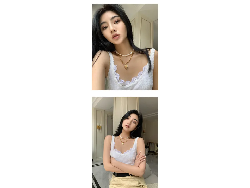 A woman wearing a layered pearl and gold heart pendant necklace.