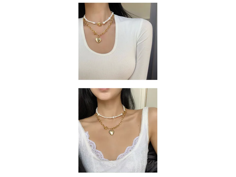 Close-up of a layered pearl and gold heart pendant necklace on a model.