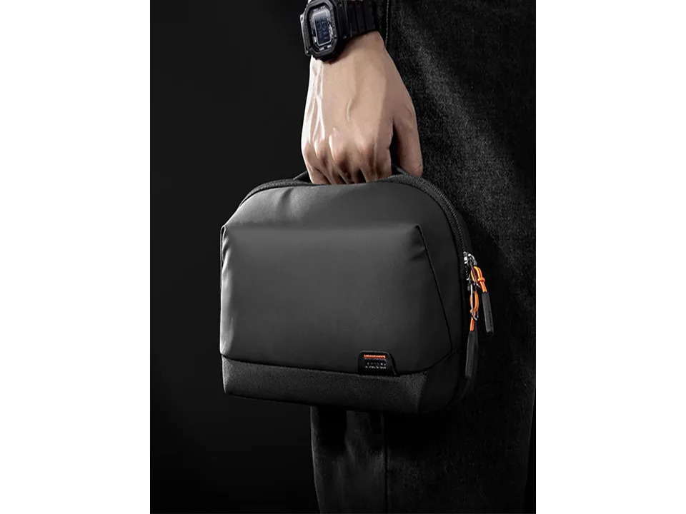 A person holding the black digital storage bag by its handle.
