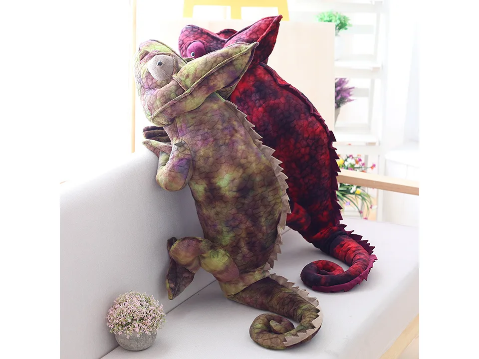 Green and red plush chameleon toys sitting on a sofa.