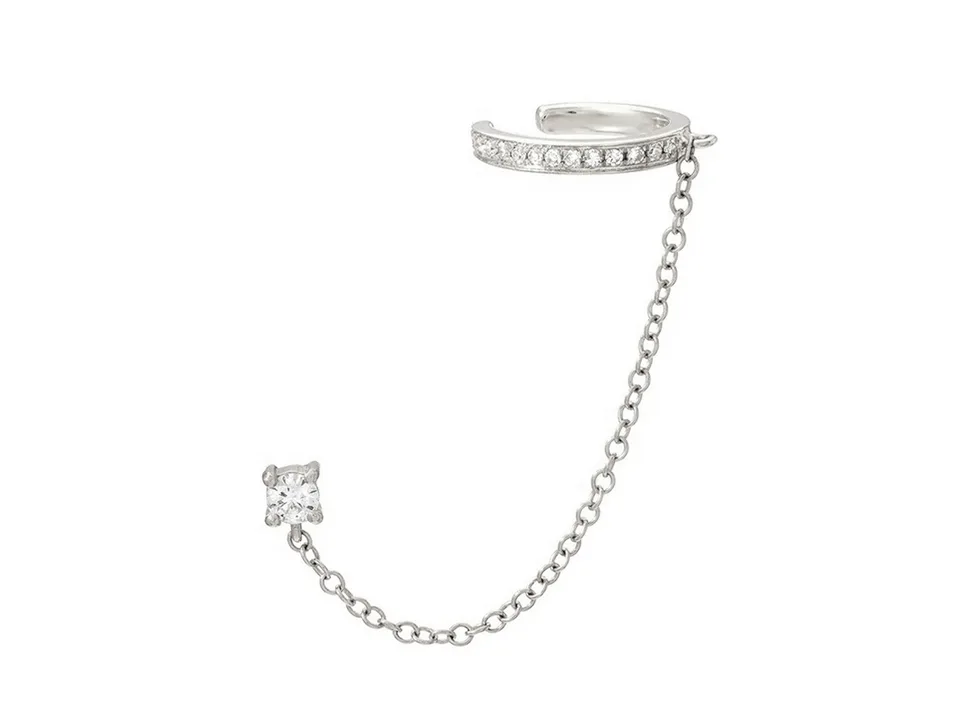 A silver ear cuff connected to a single crystal stud by a delicate chain.