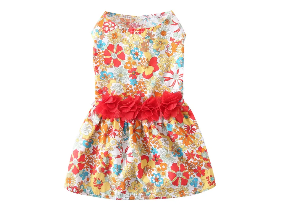 A sleeveless dog dress with a colorful floral pattern and a row of red fabric flowers at the waist.