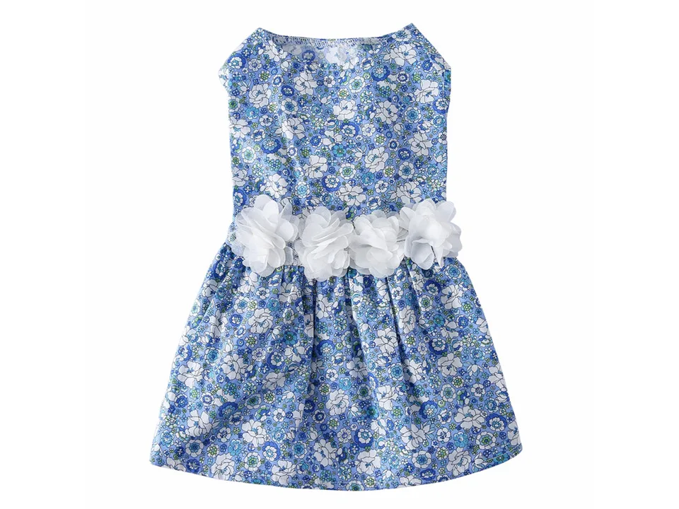 A sleeveless dog dress with a blue floral pattern and a row of white fabric flowers at the waist.