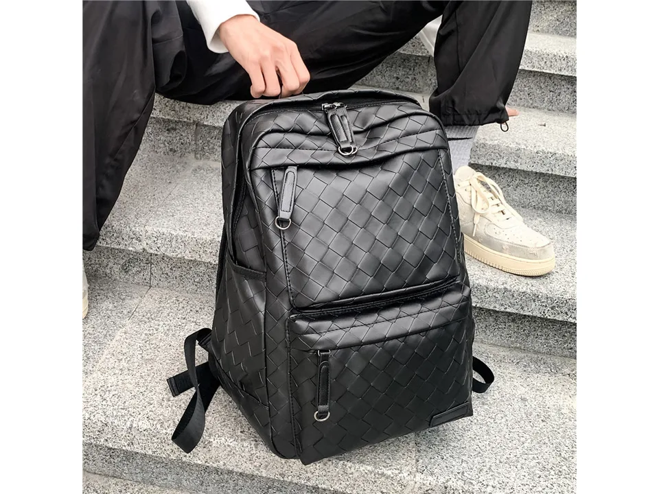 Person sitting on stairs with the black woven backpack.