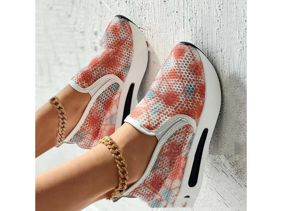 A pair of orange and blue mesh slip-on shoes with white platform soles shown from the side.