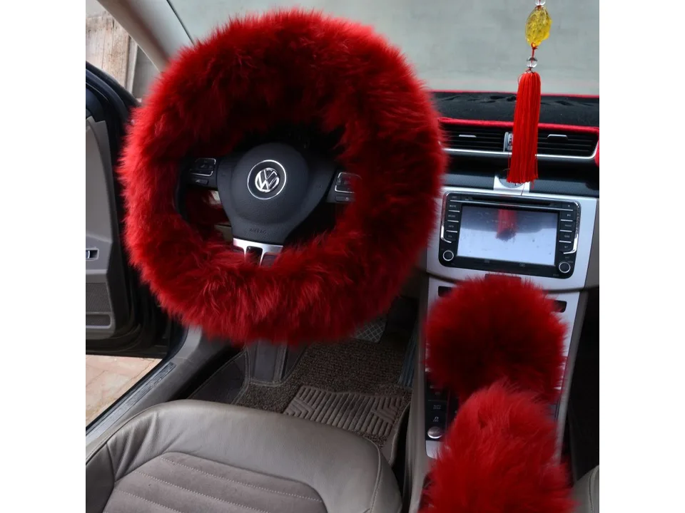 Red plush steering wheel cover and matching gear shift cover installed in a car.