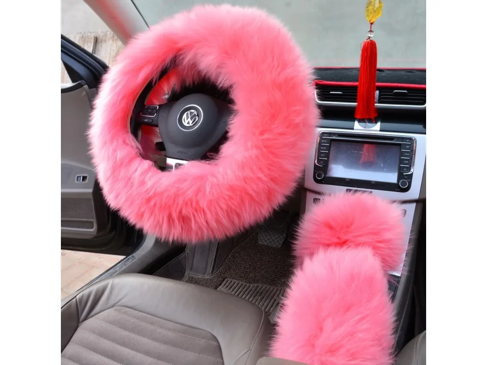 Pink plush steering wheel cover and matching gear shift cover installed in a car.