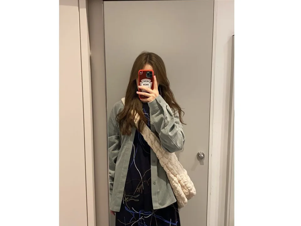 A person wearing the white quilted shoulder bag over their shoulder.