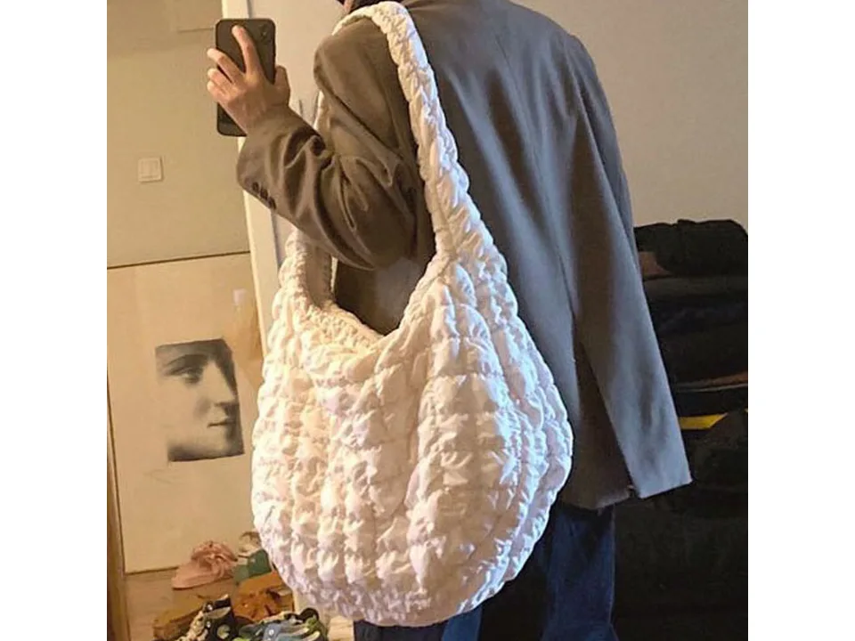 A person wearing the white quilted shoulder bag, viewed from the side.