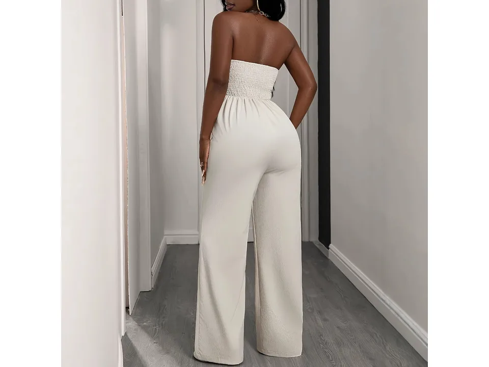 Back view of a woman wearing a beige strapless jumpsuit.