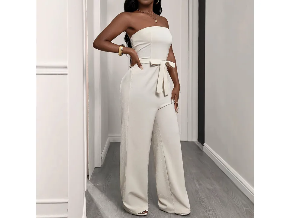 Front view of a woman wearing a beige strapless jumpsuit with a belt.
