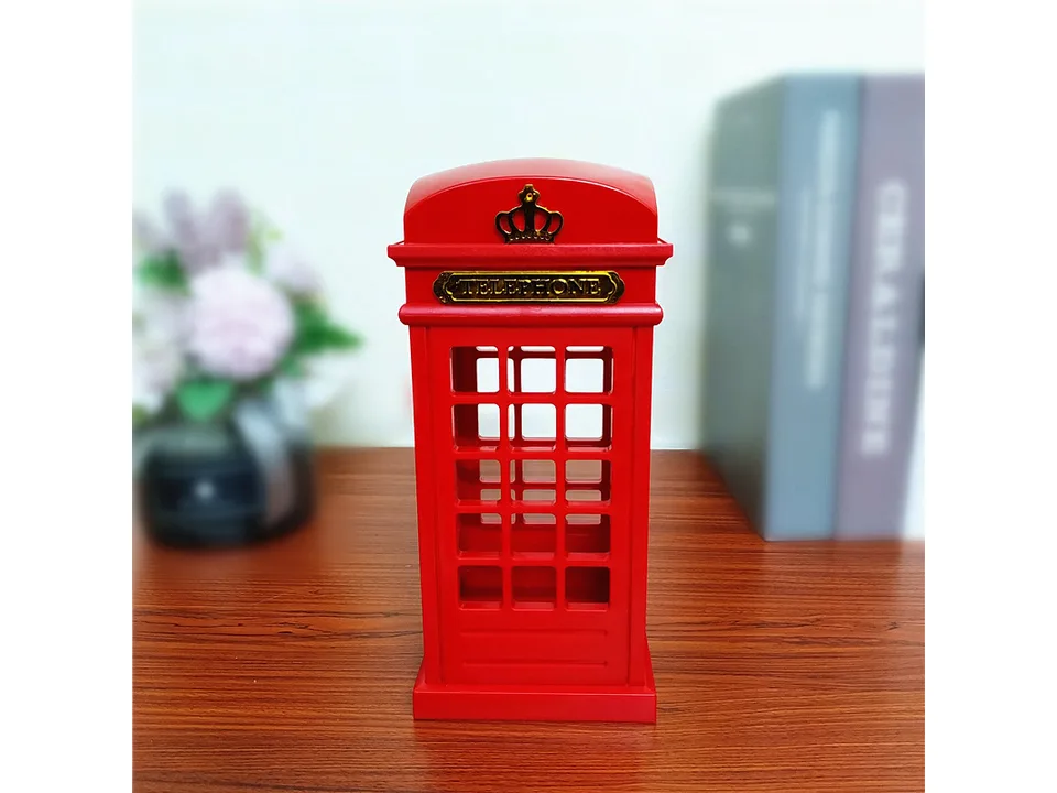 A red telephone booth style lamp standing on a wooden surface.