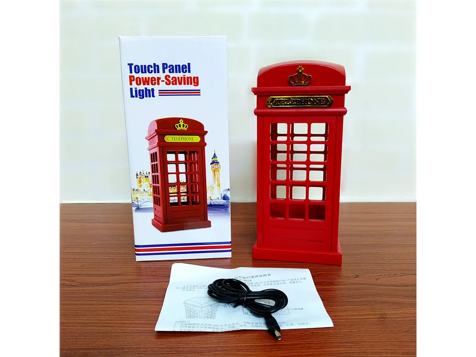 The telephone booth lamp next to its retail box, a charging cable, and the instruction manual.