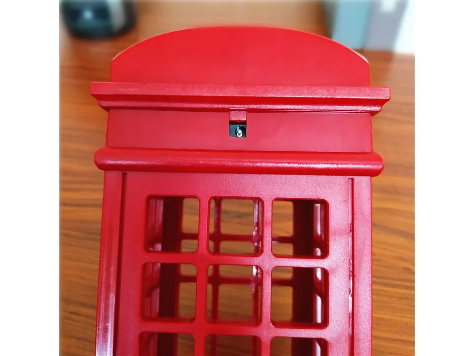 Close-up of the top section of the red telephone booth lamp showing the power input port.