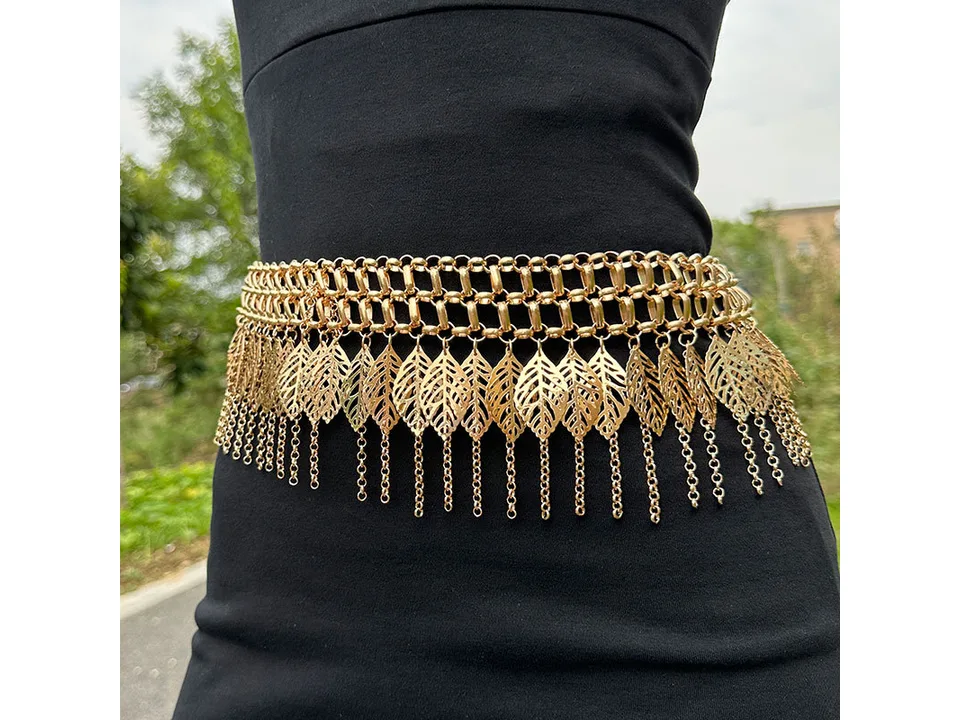 Gold-tone multi-layer leaf tassel chain worn as a waist belt on a person.