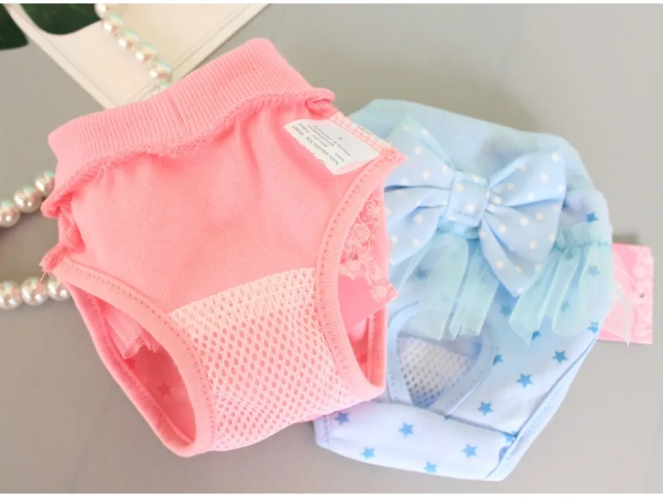 Pink and blue dog menstrual pants showing the mesh lining and fabric tag.