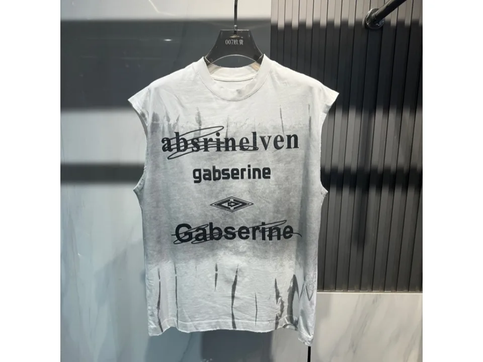 White sleeveless tank top with black graphic print hanging on a hanger.