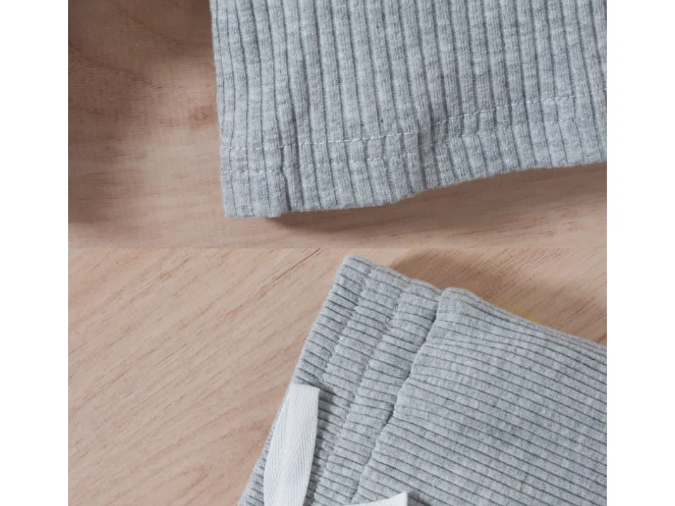 Close-up of the ribbed fabric texture and the elastic waistband of the pants.
