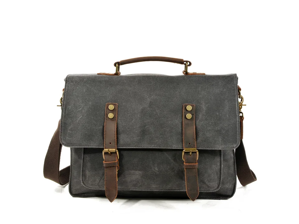 Front view of a grey canvas messenger bag with leather straps.