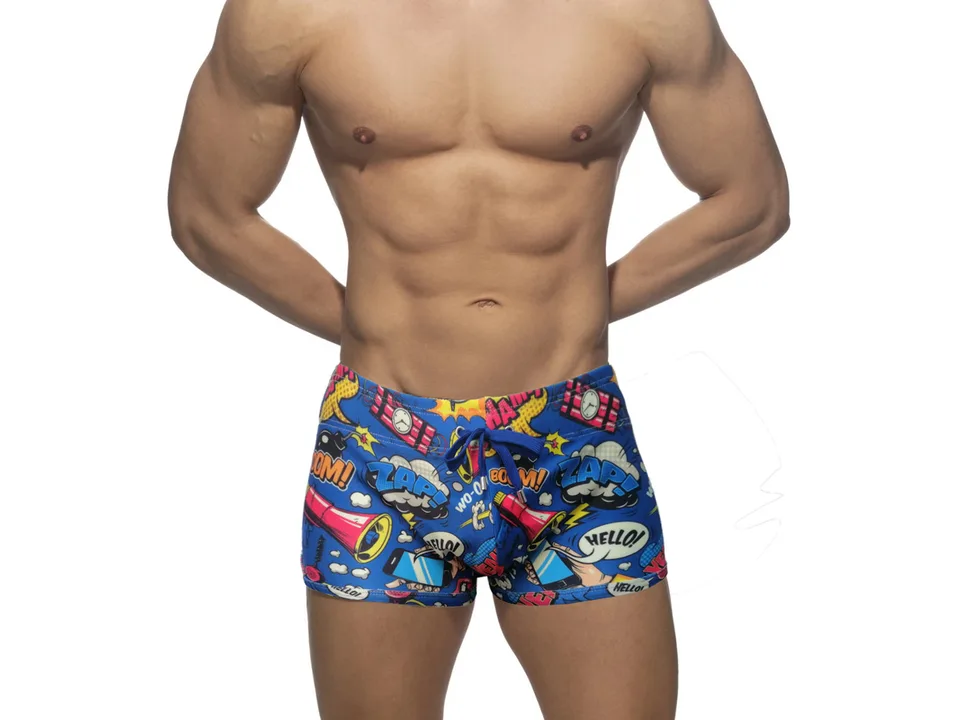 Front view of blue comic print swim trunks on a male model.