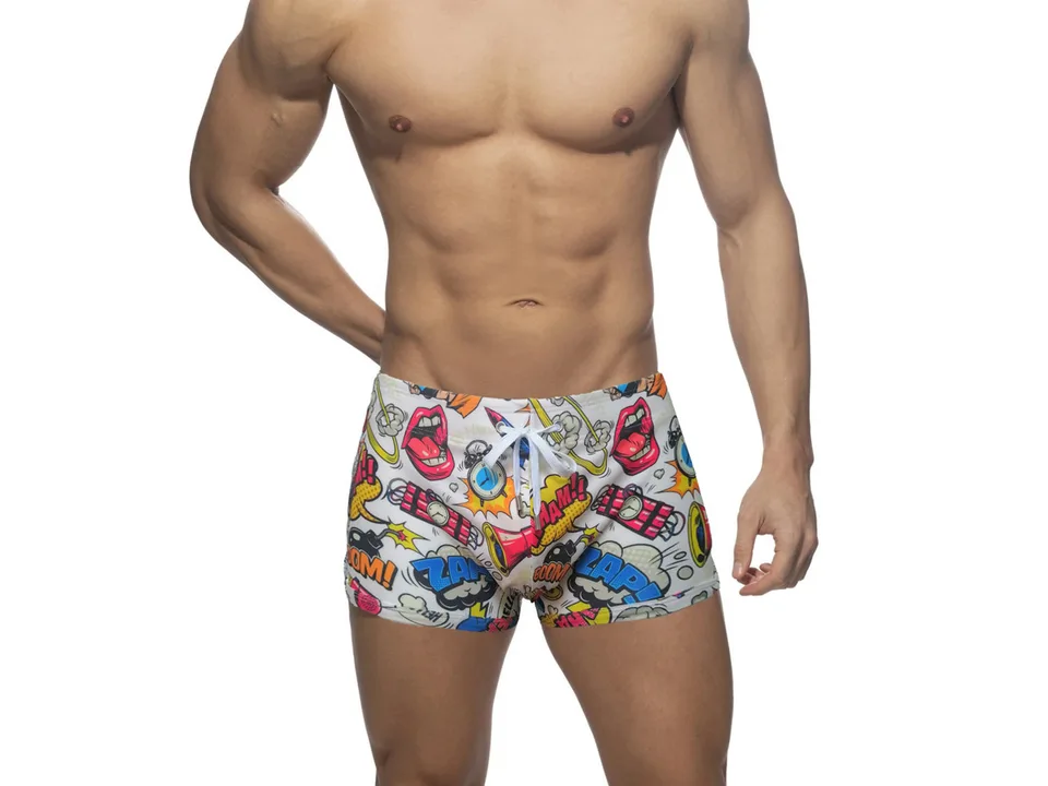 Front view of white comic print swim trunks on a male model.