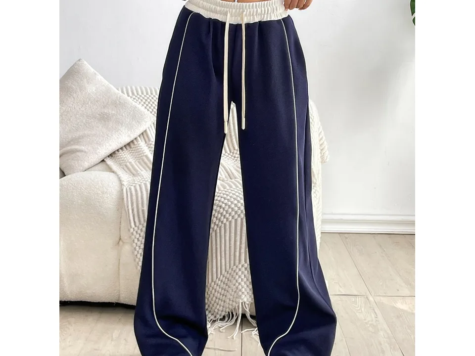 Front view of navy blue wide-leg sports trousers with a white drawstring waist and side stripe.