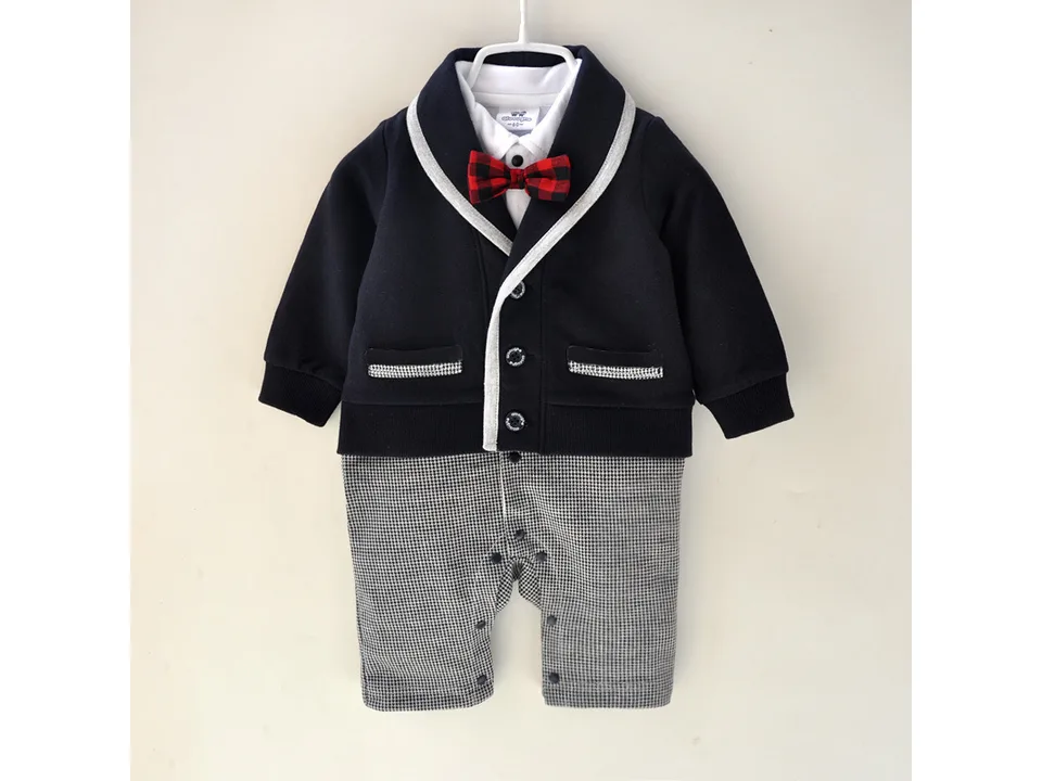 A baby boy formal jumpsuit with a navy jacket top, red plaid bow tie, and houndstooth pants.