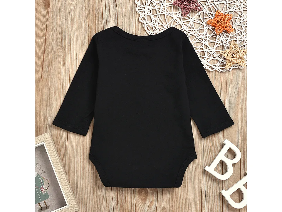 Back view of the plain black long-sleeve baby bodysuit on a wooden background.