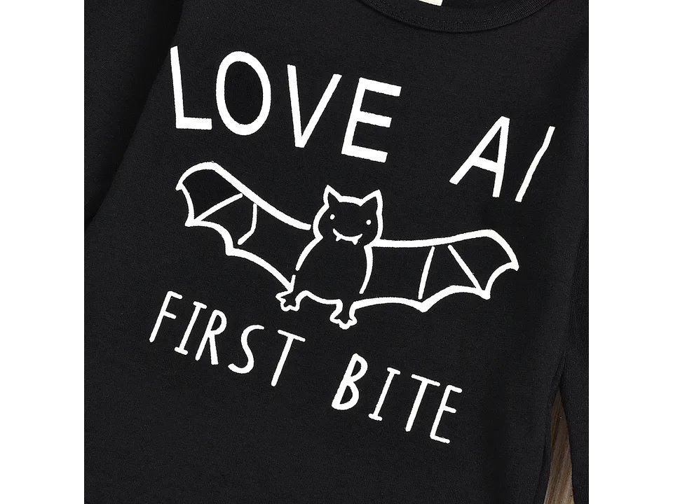 Close-up of the bat graphic and text 'Love at first bite' on the black baby bodysuit.
