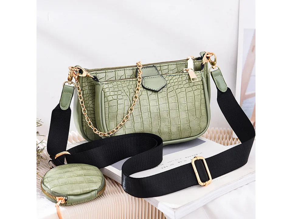 Green crocodile-pattern crossbody bag with a gold chain and small round coin purse.