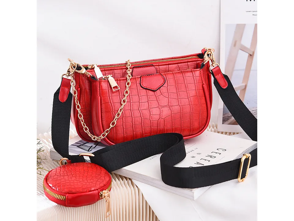Red crocodile-pattern crossbody bag with a gold chain and small round coin purse.