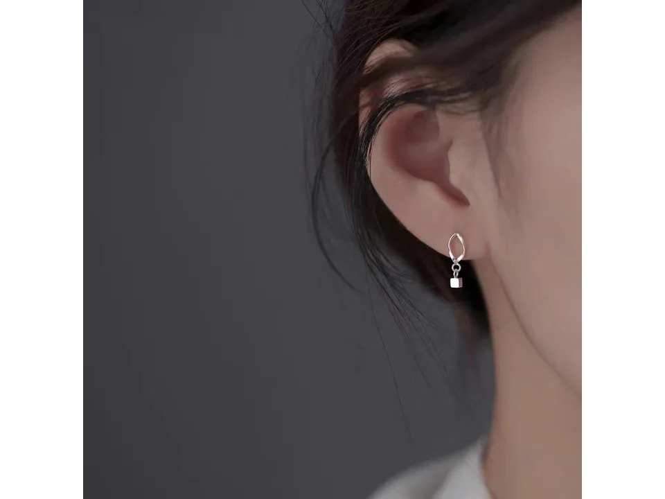 A woman wearing the geometric square drop earring.