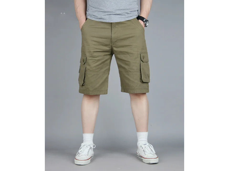 A man wearing olive green cargo shorts with side pockets.