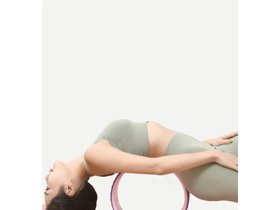Woman using a yoga wheel for back stretching.