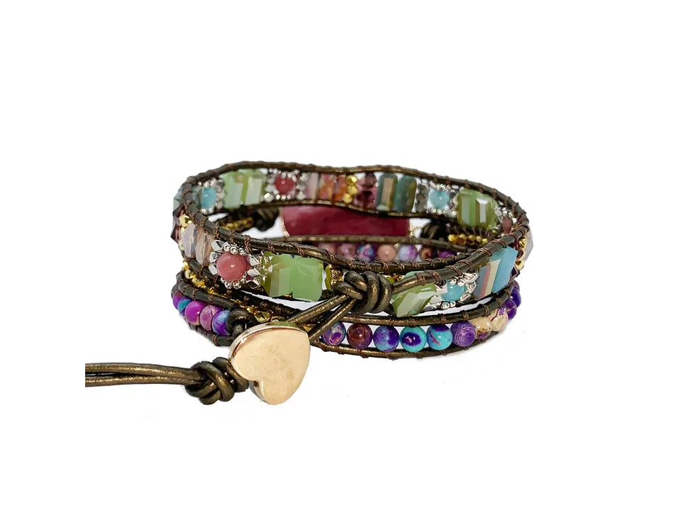 Close-up of the multi-layer leather bracelet showing the heart-shaped clasp and bead details.