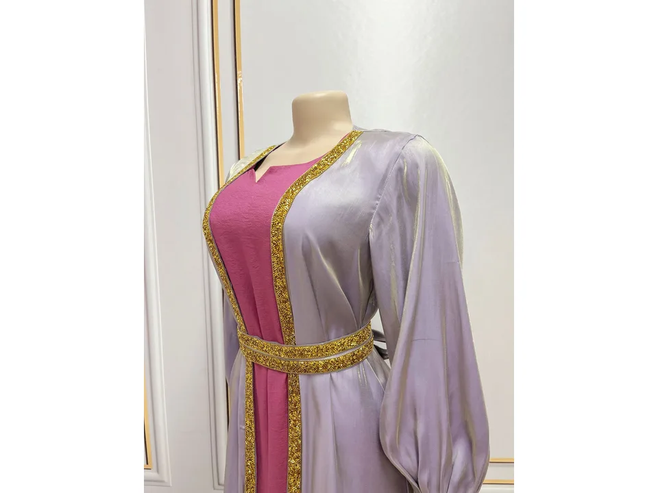 A mannequin wearing the purple maxi dress and light purple jacket with gold trim.